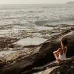 photo of woman sitting on rock