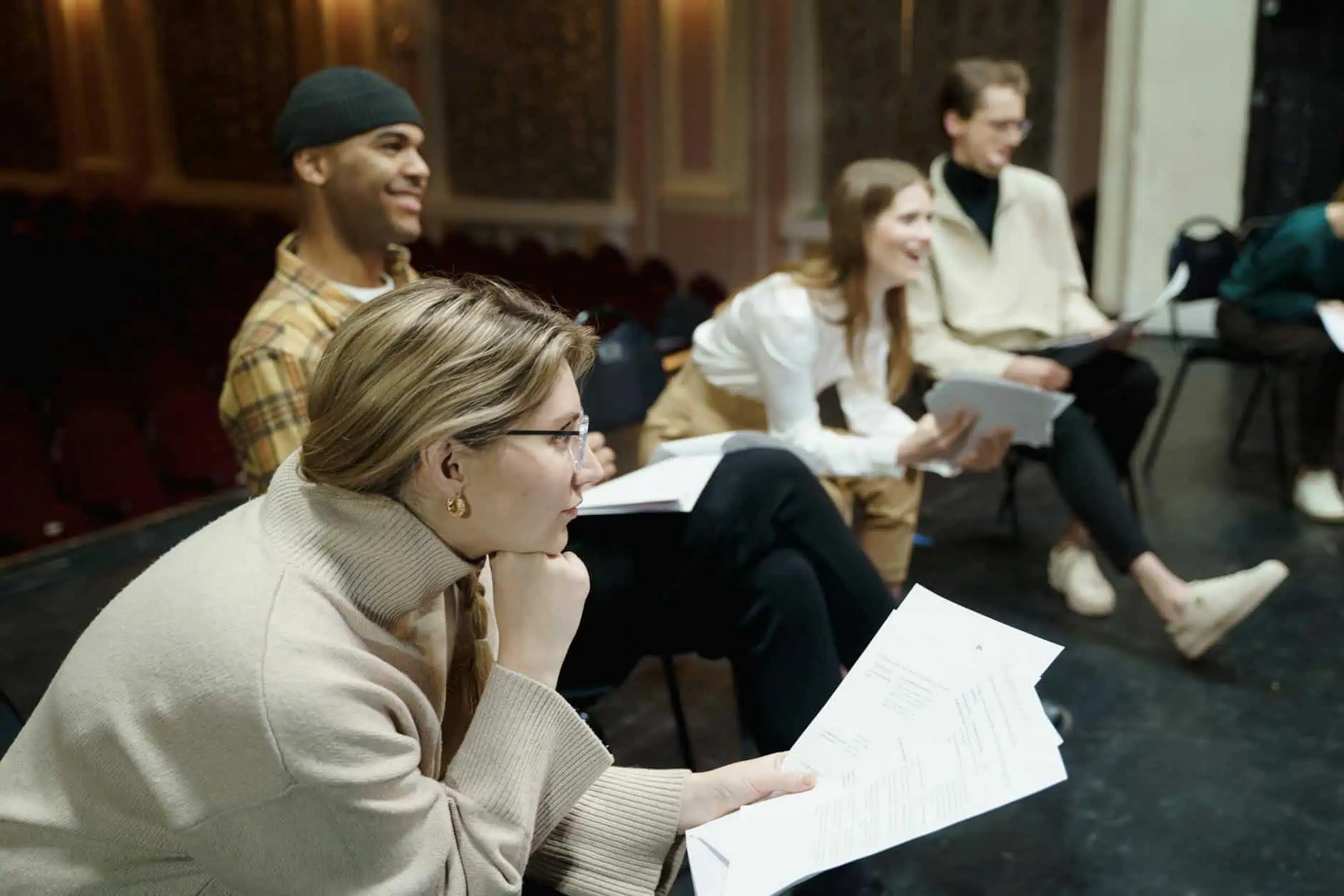 group of people sitting with their scripts. Mental health with actors at work.