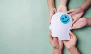 Happy face emoticon inside a paper head diagram representing mental health and psychological well-being at Davenport Psychology.