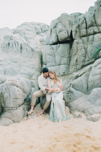couple sitting on the rocks by the sea