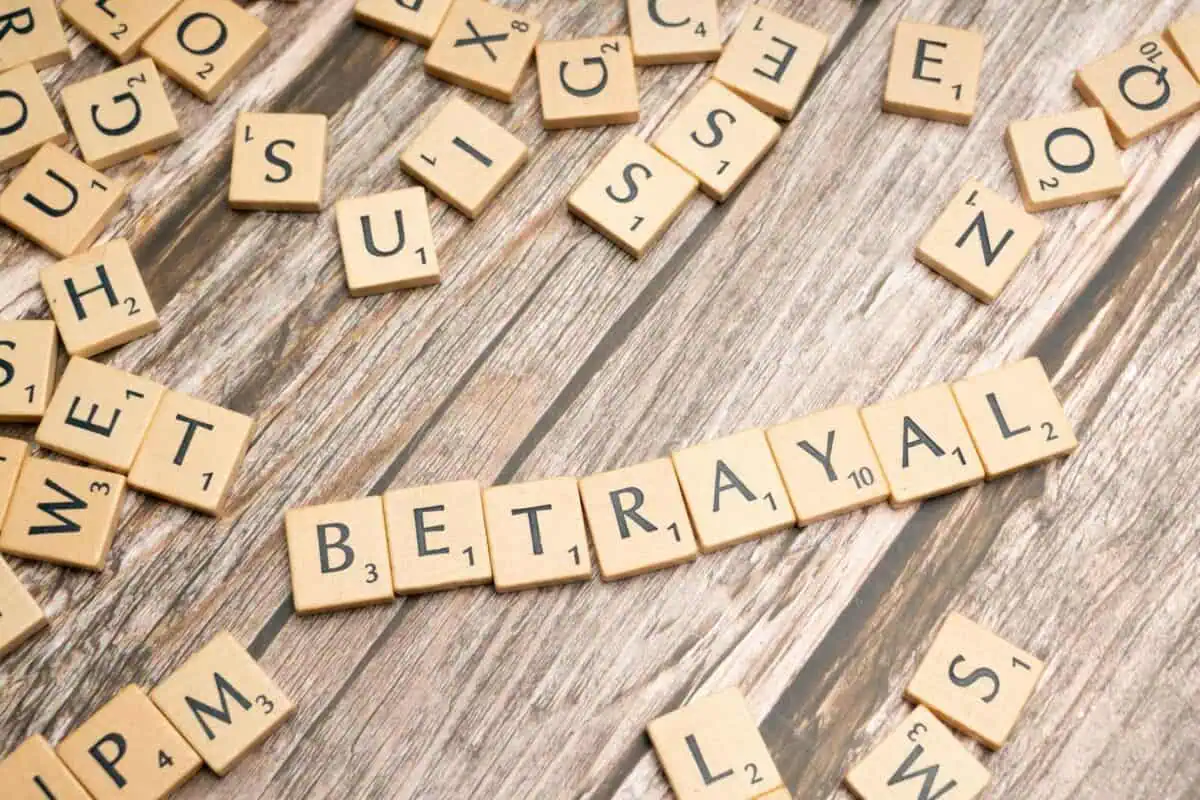 the word betrayal spelled out in scrabble tiles