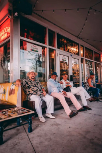 people sitting on brown wooden bench in front of a restaurant