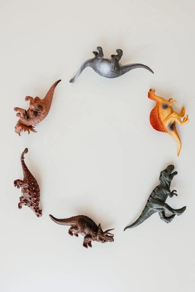 dinosaur toys in circle on the white surface