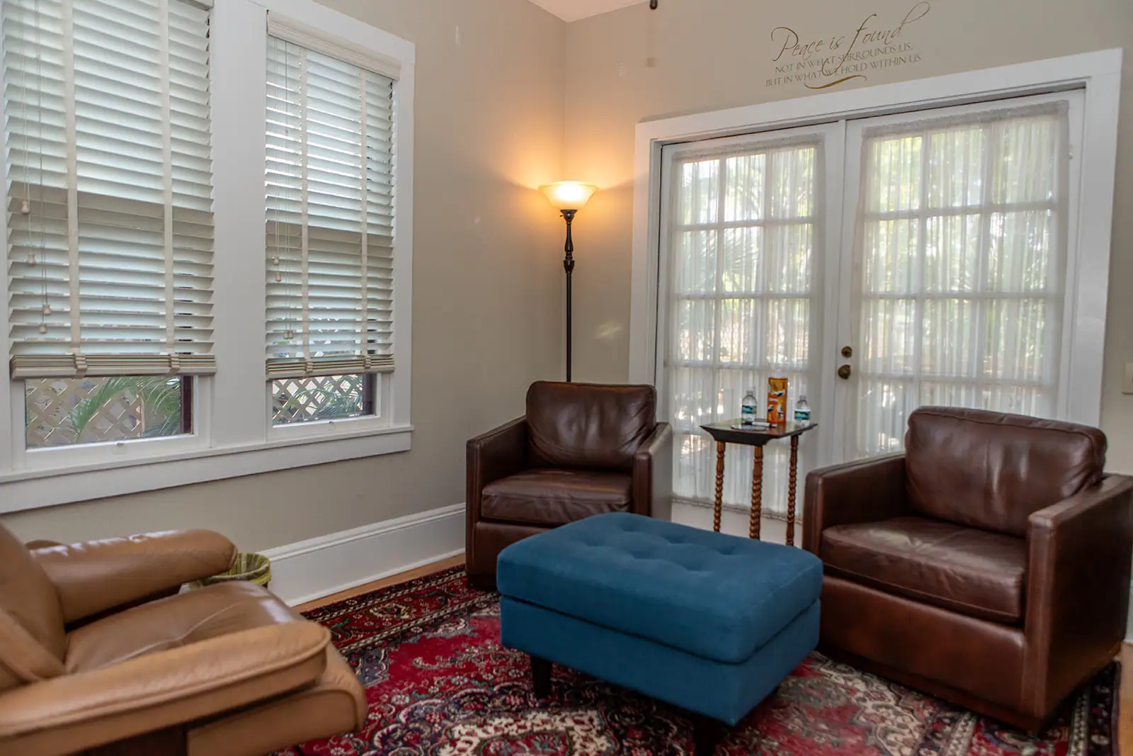 A private and comfortable therapy room at Davenport Psychology in Sarasota, Florida, furnished with leather chairs and a blue ottoman to ensure client comfort and confidentiality.