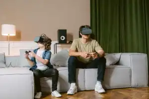 man in brown polo shirt and black pants sitting on gray couch