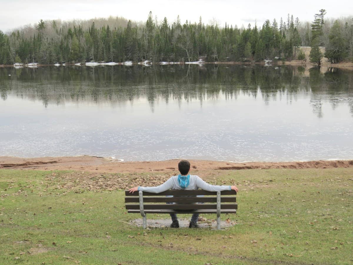 A man sitting alone, holding his head in reflection