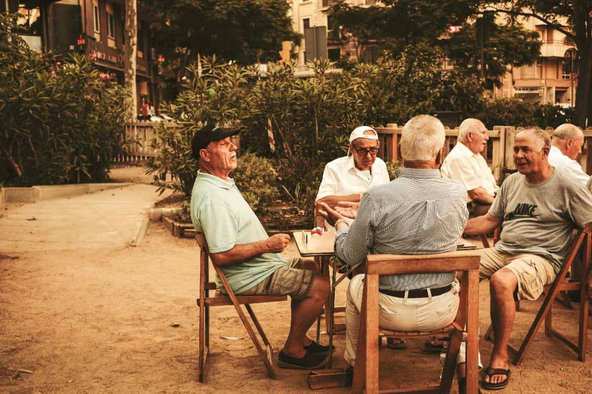 A group of men in a supportive group setting, sharing personal stories