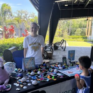 Dr. Keri Downs sharing Summer Zen family support resources at a Sarasota community event.